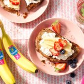 Vollkornbrot mit fettfreiem Hüttenkäse, Chiquita Bananen, Erdbeeren, Blaubeeren und Sesamsamen