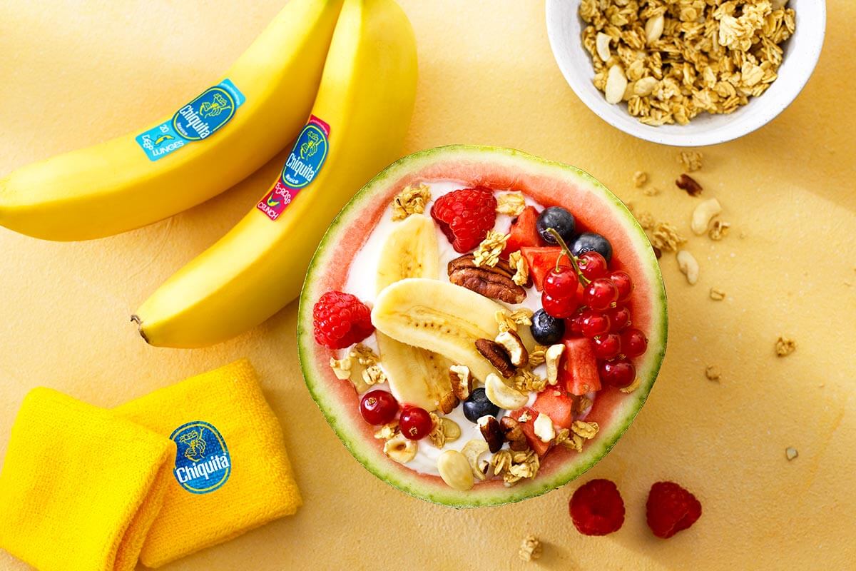 Obstsalat in Wassermelone mit Joghurt, Chiquita Bananen und roten Früchten