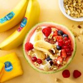 Obstsalat in Wassermelone mit Joghurt, Chiquita Bananen und roten Früchten